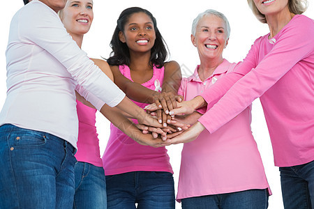 穿着乳癌丝带的快乐妇女们手牵手在一起图片