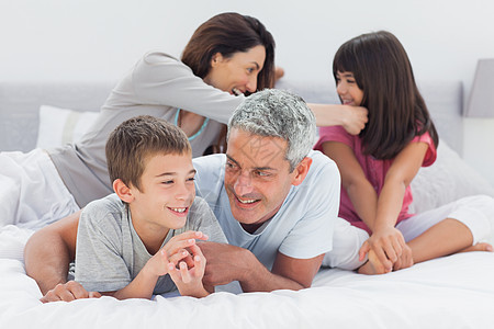 家人一起躺在床上男性家庭男生房子父亲棕色孩子快乐女孩女士图片
