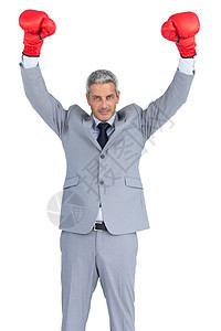 商务人士用红色拳击手套举起手来装扮图片
