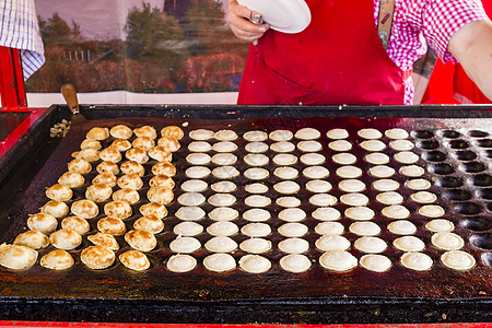 鲜烤的荷兰传统小型煎饼 叫做 Poffertjes牙签圆形棕色烤箱工作面粉面包男人午餐美食图片