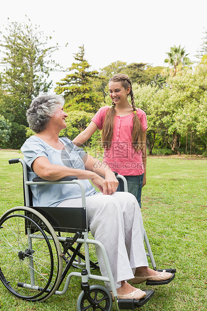 幸福的孙女在轮椅上与祖母交谈图片