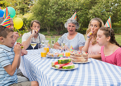 家庭在野餐桌外庆祝女孩生日的节日图片
