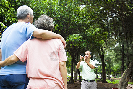 快乐的老人们在旅行中用智能手机拍照图片