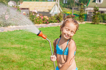 可爱快乐的小女孩 从水管里倒水 笑着图片