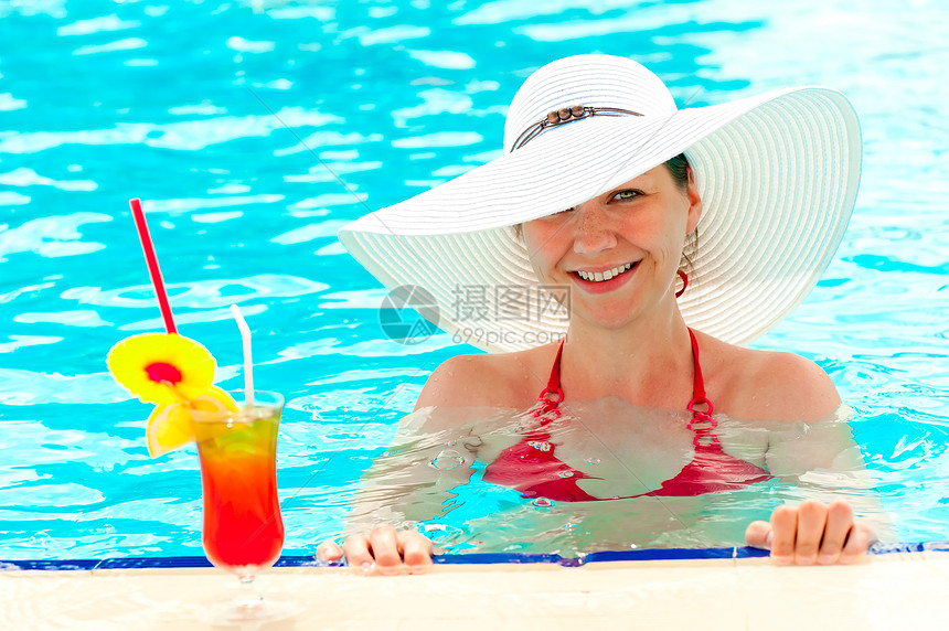 在游泳池里戴着白帽子的年轻女孩图片