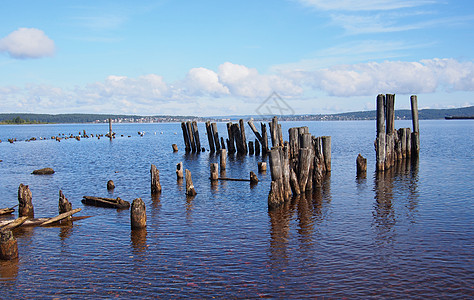 湖中的旧堆积物蓝色海滩旅行天空码头反射丘陵运输木头晴天图片