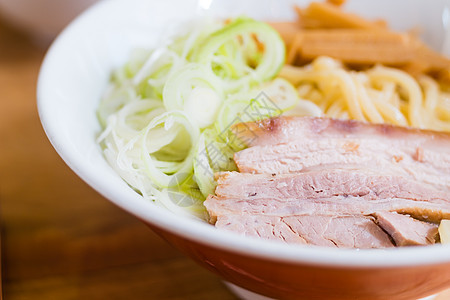 猪肉和洋葱在红碗面面上切桌子面条黄色木头美食食物午餐拉面文化餐厅图片