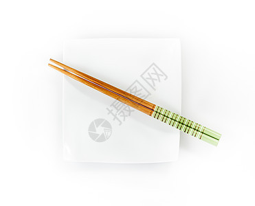 在白色背景上被孤立的板块上的筷子餐具绿色盘子图片