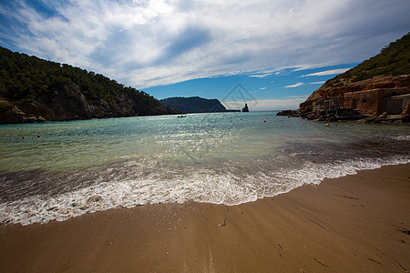 伊比萨卡拉贝尼拉斯海滩 在巴利阿里的圣琼蓝色假期海洋石头岩石支撑海岸天空泡沫波浪图片