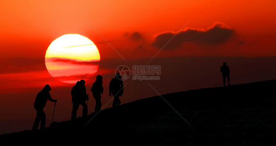 一群游客在日落时乘车到山上图片