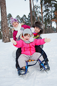 儿童在雪雪地上骑着雪橇幸福青年男生童年孩子兄弟儿子美丽家庭姐姐图片