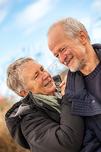 快乐的成熟情侣 放松黄海沙丘微笑成人活力夫妻退休喜悦闲暇假期蓝色女士图片