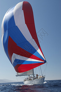 乘着彩色帆船在游艇赛艇上与清蓝的天空对冲图片