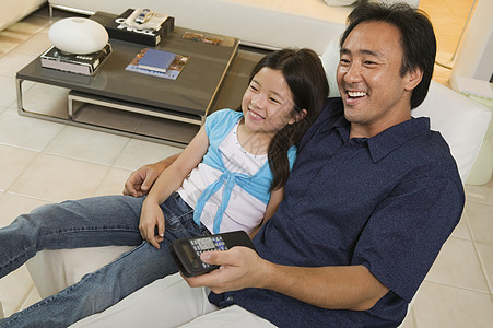 父亲和女儿一起在客厅看电视 高角度视野图片