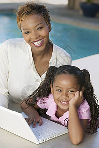 母亲和女儿用笔记本电脑在天台肖像上高角度视图图片
