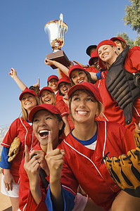 年轻多种族女子棒球队在胜利比赛后欢呼的快乐青年 多族裔女性棒球队图片