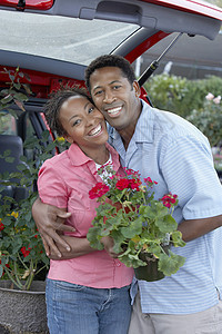 一对快乐的非裔美国人夫妇在植物园 购买陶工厂的肖像图片