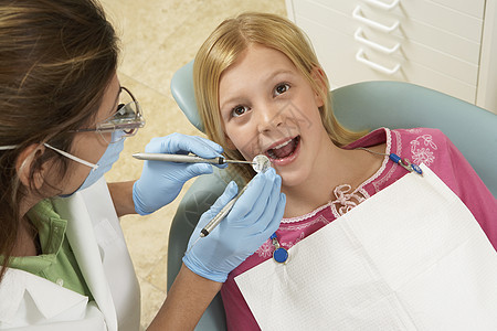特写在牙科诊所检查牙齿的一个女孩的牙部;图片
