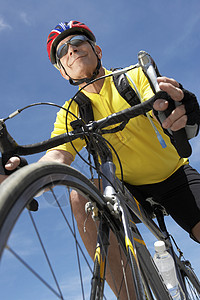 高级男性骑自行车骑骑自行车乘天的低角度视图图片