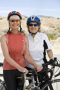 高级女性朋友在街上骑自行车站立的肖像图片