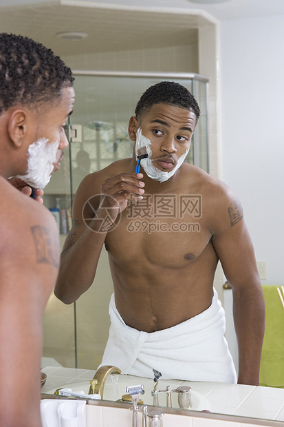 非洲裔美国青年男子在浴室镜子前刮剃胡须剃刀男士房子奶油男人刮胡子毛巾反射卫生成人图片