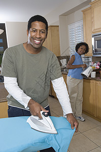 一个快乐男人的肖像 和厨房里的女人一起熨衣服图片