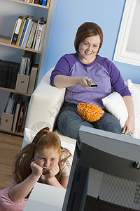 超重女孩和母亲在看电视图片