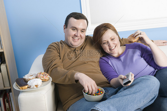 在家沙发上坐在一起的幸福肥胖情侣图片