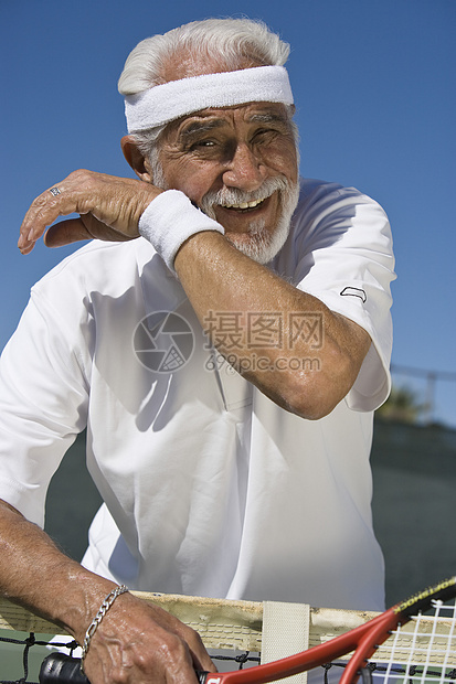 在法庭上一个疲劳的老年男性网球运动员的肖像图片