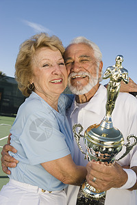 带奖杯的网球运动员退休老人生活方式闲暇幸福老年快乐胜利成就拥抱图片
