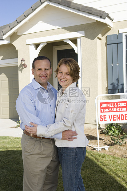 幸福的一对情侣在新房子前拥抱的肖像图片