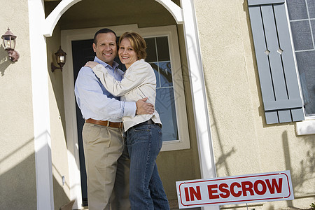 快乐的成熟情侣在新房子前拥抱图片