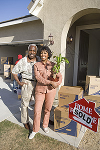 携带物品搬进新房子的非裔美籍非洲夫妇图片