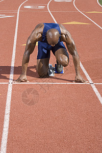 非洲裔美国男子在赛马赛道起始街区的短跑运动员图片