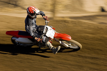 骑摩托车的男男子在赛马赛道上高速骑摩托车图片