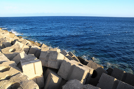 水泥破解水立方体岩石港口蓝色安全立方体海堤海岸天空风暴码头背景图片