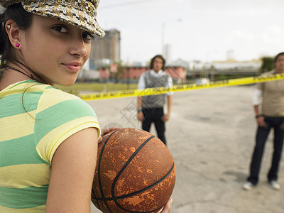 在街头肖像中打篮球的年轻女子图片