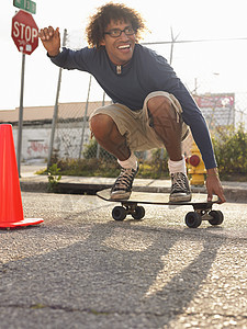 全年青年男子在城市街道上玩滑板图片
