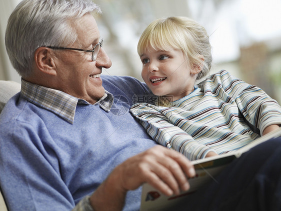 快乐的小女孩和爷爷在家读故事书的小女儿在一起边缘眼镜男人家庭孩子孙女祖父祖父母阅读女孩图片