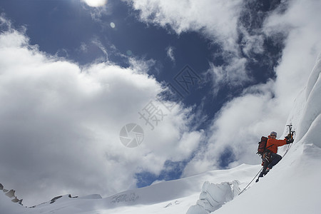 一只男性登山者的侧面景象 它向雪坡上爬去 用斧子挡云假期运动天空旅行闲暇活动冒险家成人地形挑战背景图片