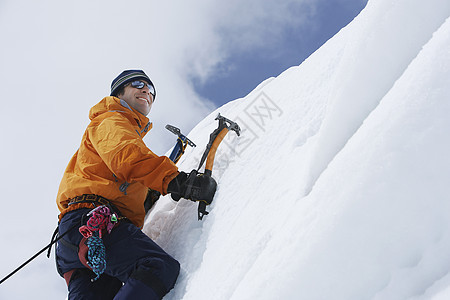 一名男性登山者的低角度视图 他们向雪坡上爬去 用斧子挡云娱乐登山山腰冒险家安全闲暇旅行远足者勘探男人背景图片