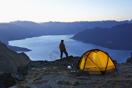 人仰望湖边 黄昏时用照明帐篷看湖图片