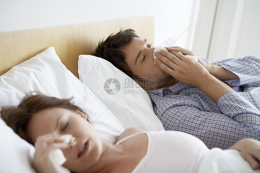 床上感寒的年轻夫妇女性成人男士流感睡衣说谎传染性男人疾病过敏图片
