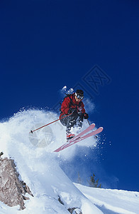 从山顶跳起的滑雪者肾上腺素粉雪休闲男人成人天空运动冒险跳跃滑雪服图片