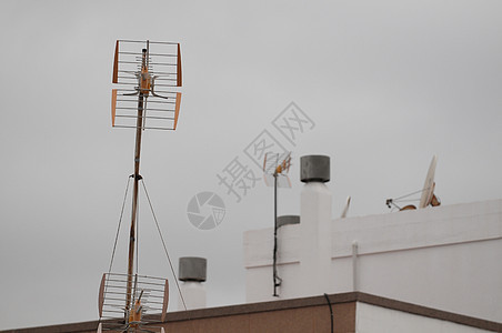 云天的屋顶上的天线工具卫星望远镜播送频率收音机日落射电蓝色信号图片