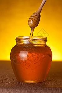蜂蜜罐加调味和流动蜂蜜木头搅拌器桌子液体用具橙子药物勺子营养帆布图片