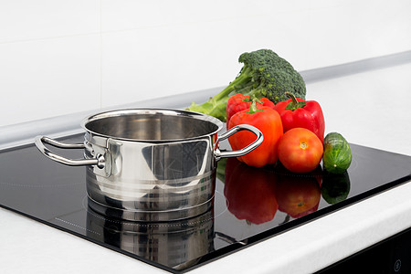 现代厨房加上岗炉灶的锅和蔬菜器具黄瓜金属盘子公寓食物烤箱美食制品陶瓷图片