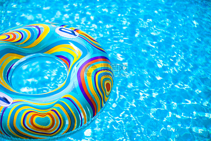 漂浮在蓝游泳池中的可充气彩色橡胶环反射水池太阳问候紫色娱乐游泳玩具假期波纹图片
