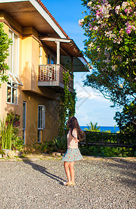年轻的黑发女人 在美丽的房子的院子里放松天堂海洋裙子游客女孩场景异国旅游碎石酒店图片