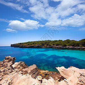 梅诺卡岛Balearic 地中海的中年卡拉和海滩悬崖海洋海景波浪支撑石头蓝色旅行太阳背景